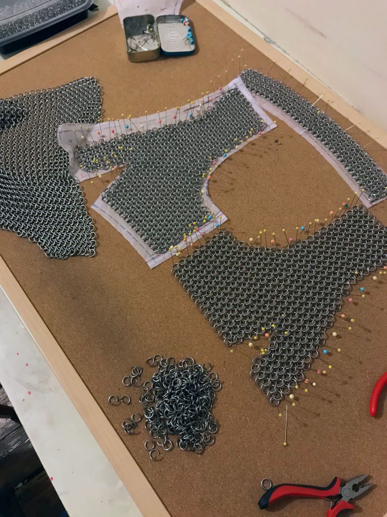 Partially assembled chainmail components for a cropped vest