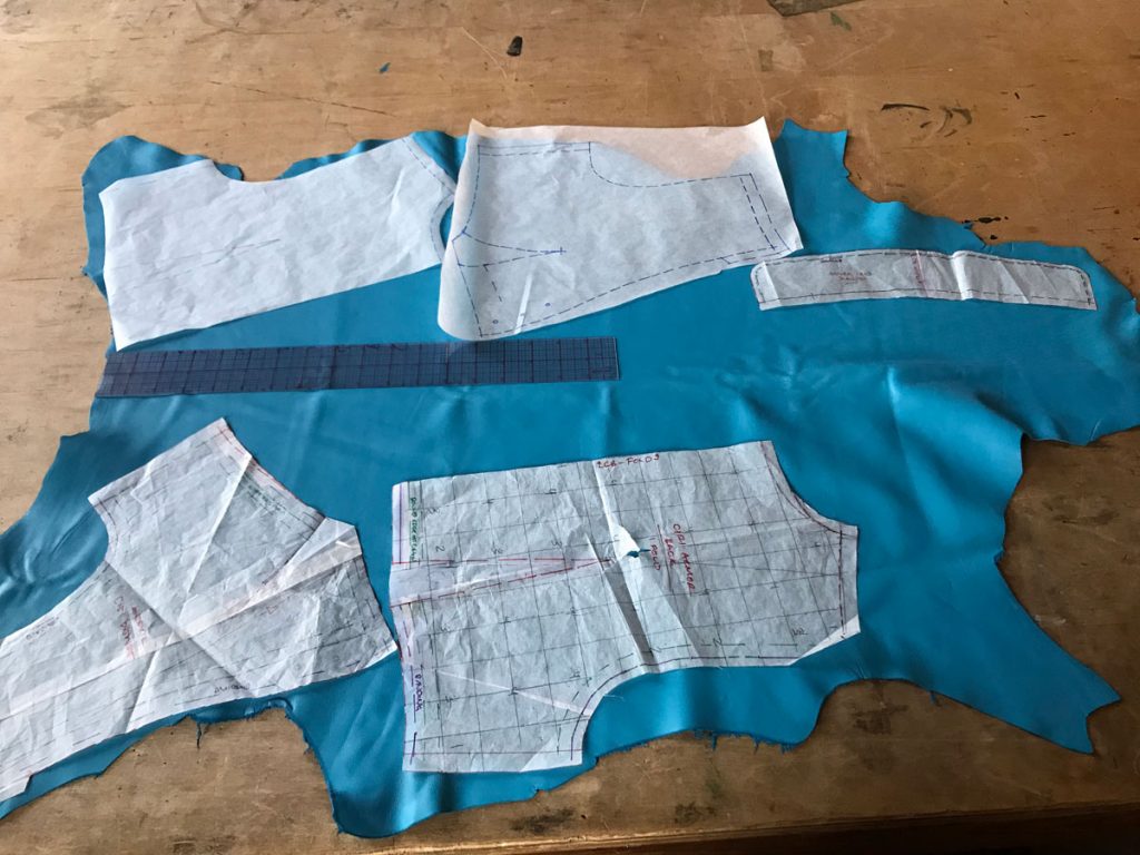 vest pattern pieces laid out on blue lambskin