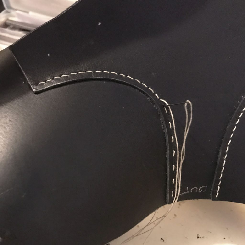 shoe seam being sewn by hand with a saddle stitch
